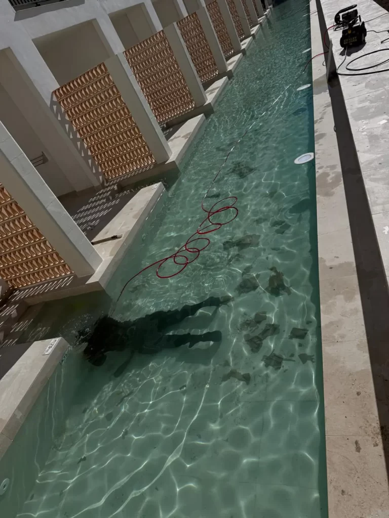 Detección de fugas en la piscina lineal de un hotel con técnico bajo el agua