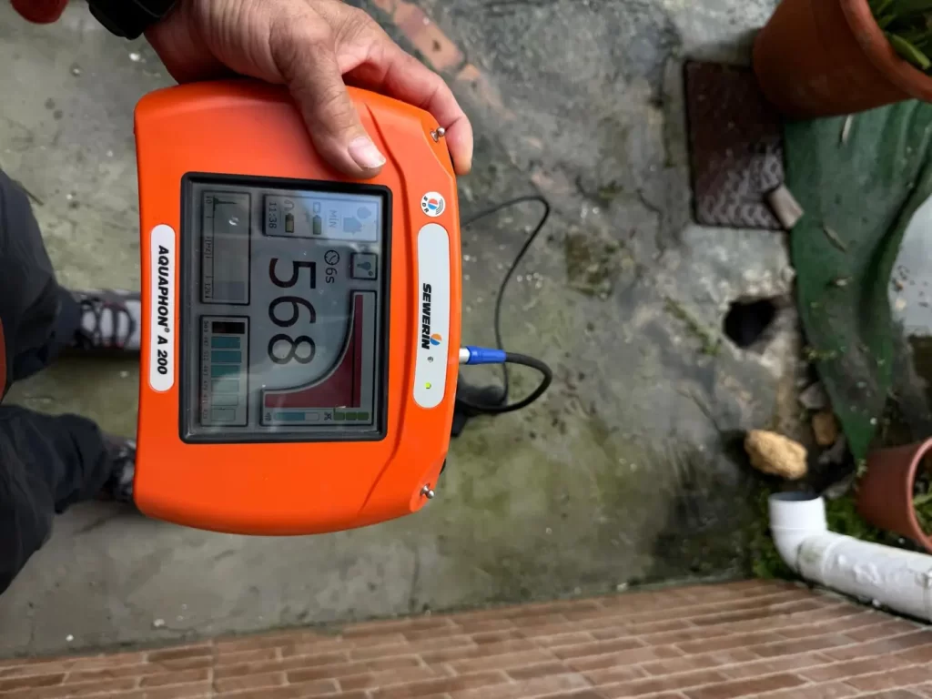 Geófono electroacústico midiendo el ruido de una fuga de agua en tubería enterrada