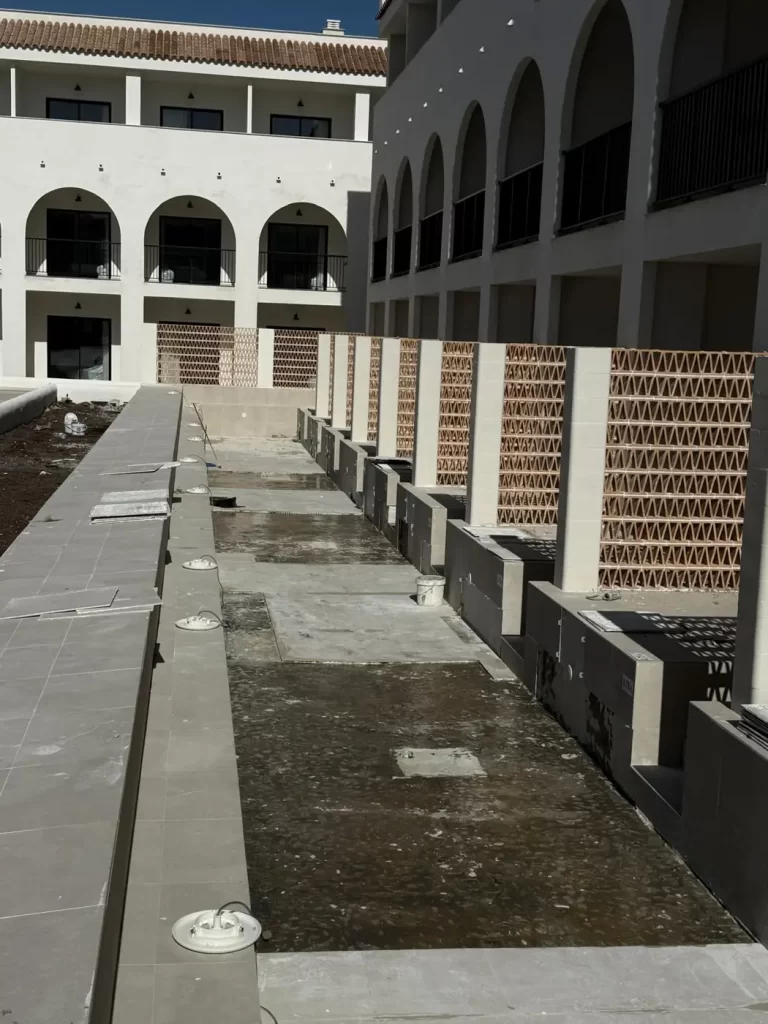 Piscina de hotel vaciada con los focos y pasamuros a la vista