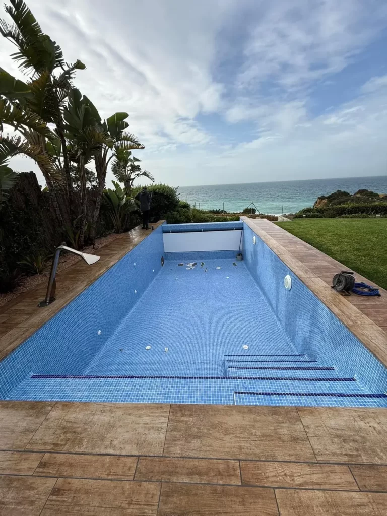 Piscina de gresite vaciada para reparar fugas en el vaso junto al mar