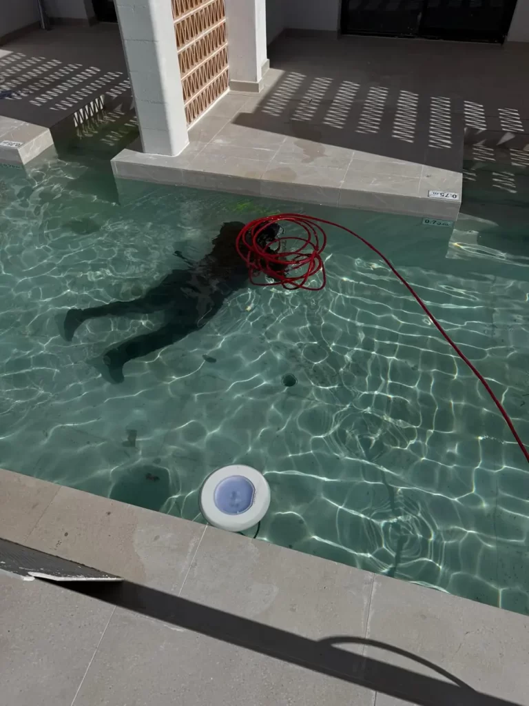 Técnico de No Más Fugas revisando el fondo de una piscina en inmersión